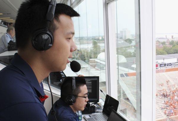 In this Sept. 5, 2015 photo, David He, left, and Bruce Lu broadcast a University of Illinois NCAA college football game from Memorial Stadium in Champaign, Ill. The two Illinois students are broadcasting Illini football games online in Mandarin Chine