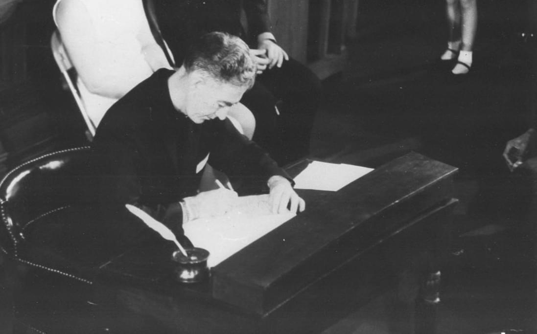 Constitutional Convention delegate, Father Francis X. Lawlor, signs the new Illinois Constitution in 1970.