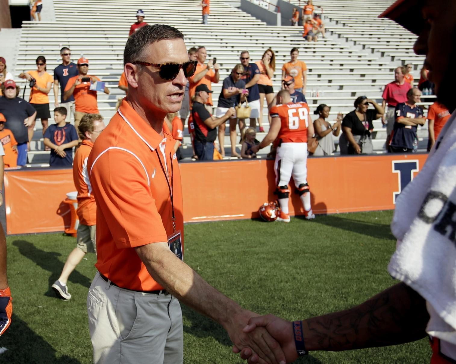 In this Sept. 5, 2015 file photo, Illinois athletic director Mike Thomas congratulates players after an NCAA college football game against in Champaign, Ill.