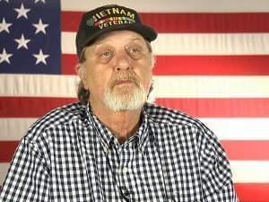 A man sitting in front of an American flag
