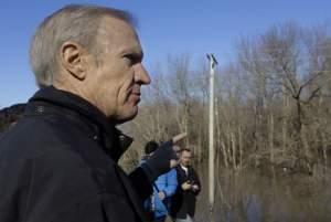 Illinois Gov. Bruce Rauner overlooks the south fork of the Sangamon River, where two teenagers were killed while crossing a flooded road last week, during his tour to the area Sunday in Kincaid, Ill