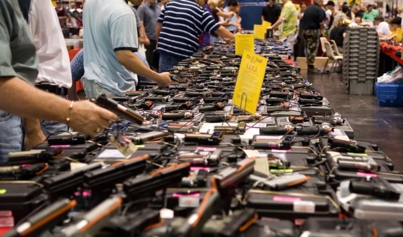 Attendees examining guns for sale at a gun show in Houston, Texas.