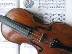violin laying on top of a sheet of music