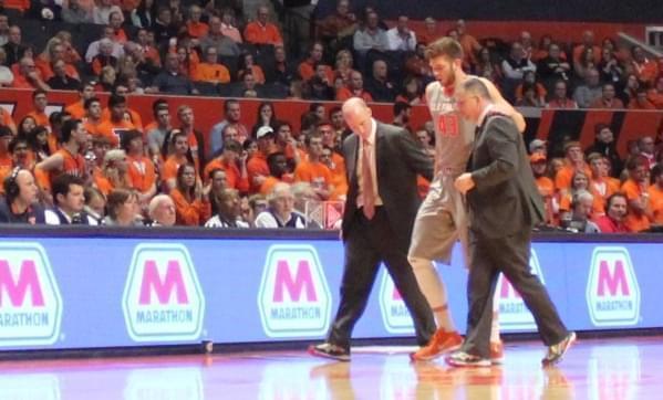 Illinois forward Michael Finke is helped off the court after hurting his knee in a collision with another player. 