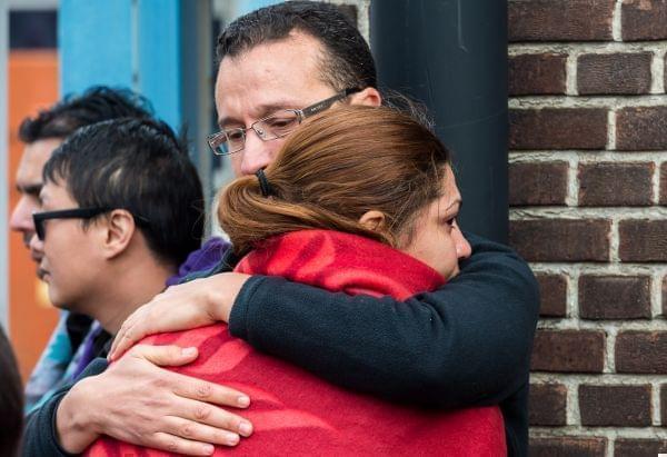 People comfort each other after being evacuated from Brussels airport, after explosions rocked the facility in Brussels, Belgium, Tuesday March 22, 2016. 