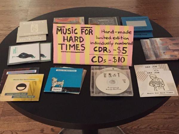 Compact discs, etc. spread out on a table for sale.