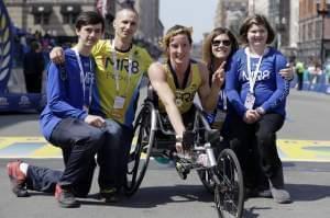 Tatyana McFadden, of Clarksville, Md., center, winner of the women's wheelchair division of the 120th Boston Marathon, poses with the family of 2013 bombing victim Martin Richard, on Monday, April 18, 2016, in Boston. From left Henry and Bill Ri