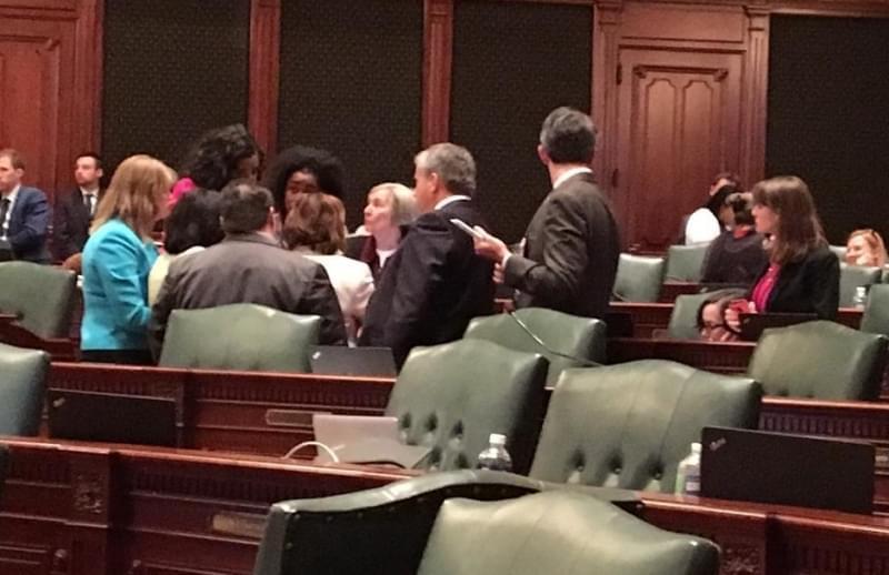 Democratic House members huddle around Majority Leader Barbara Flynn Currie's desk.