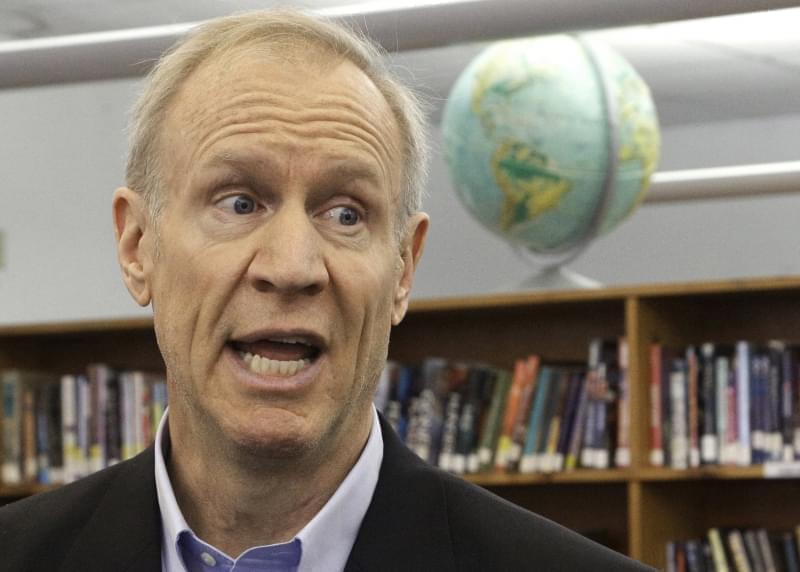 In this Wednesday, May 11, 2016 photo, Illinois Gov. Bruce Rauner visits with students at New Berlin High School in New Berlin, Ill. Rauner's vision of a grand, two-year budget compromise with Illinois lawmakers is becoming more difficult to acc
