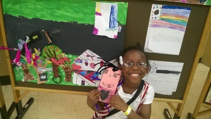 third grader Alannah Lowery shows some of the artwork she created as part of the 21st Century program