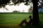 person under a tree reading