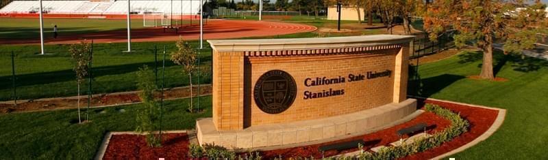 The Cal State Stanislaus logo on a sign by the university track.
