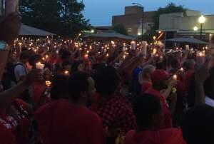 Hundreds of people raise up lit candles at a memorial vigil for Devon McClyde.