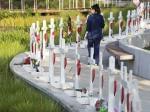 Woman walking past installation of white crosses in Orlando, Florida