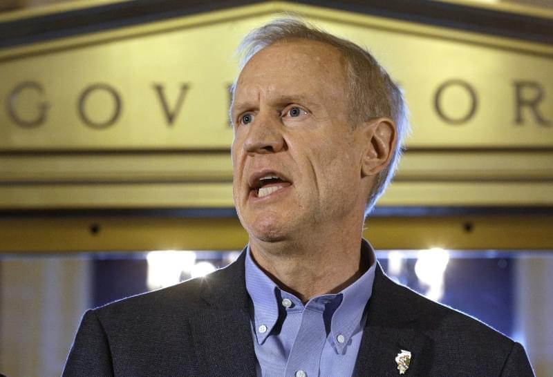 In this Thursday, June 30, 2016 photo, Illinois Gov. Bruce Rauner speaks to reporters in front of his office at the Illinois State Capitol in Springfield, Ill., after lawmakers passed a stop gap budget.