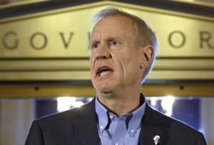 In this Thursday, June 30, 2016 photo, Illinois Gov. Bruce Rauner speaks to reporters in front of his office at the Illinois State Capitol in Springfield, Ill., after lawmakers passed a stop gap budget.