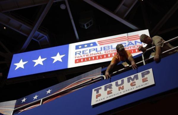 Workers place a sign as they prepare at Quicken Loans Arena in Cleveland for the Republican National Convention .