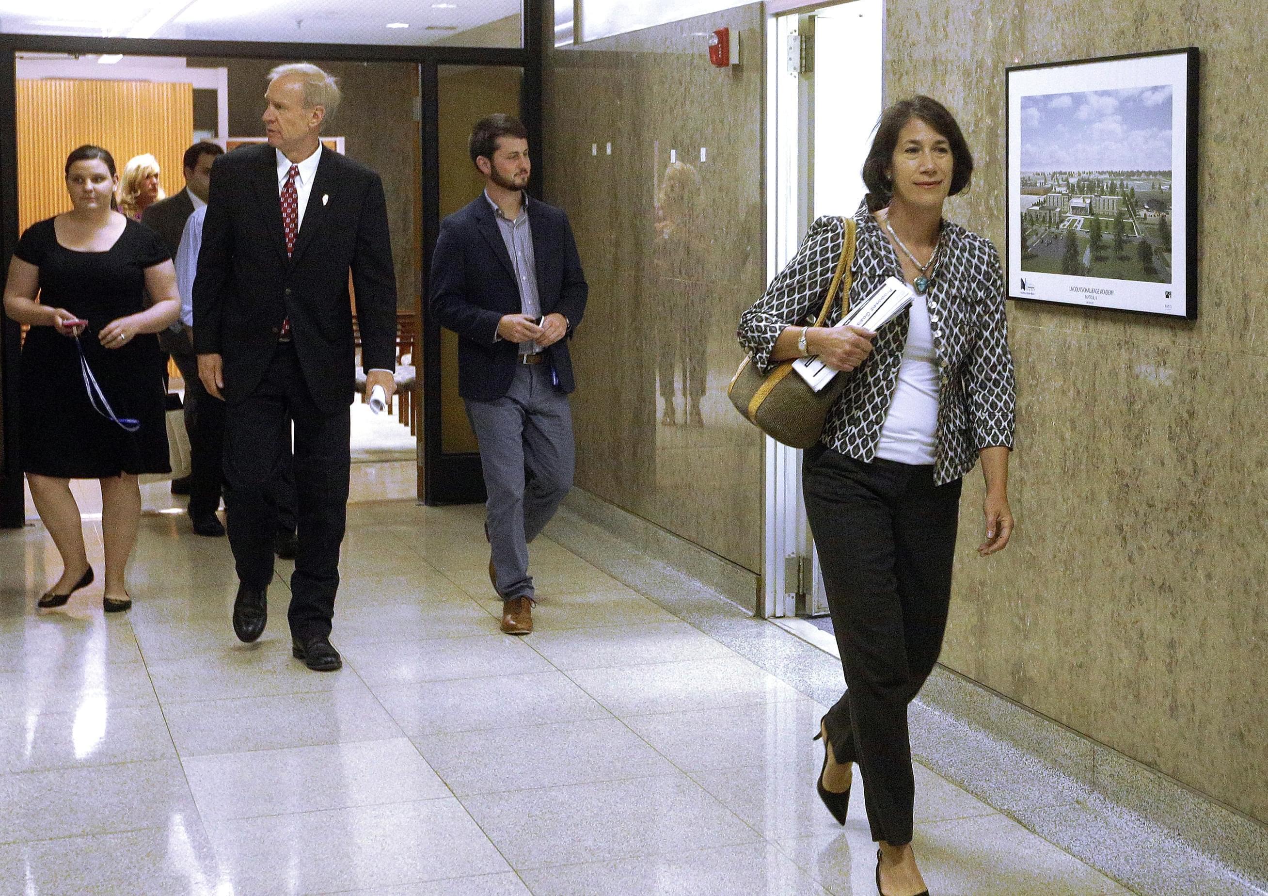 Illinois Gov. Bruce Rauner, left, and his wife Diana Rauner, right, walk down a hallway leading to a meeting of the governor's Cabinet on Children and Youth Thursday, June 9, 2016, in Springfield.