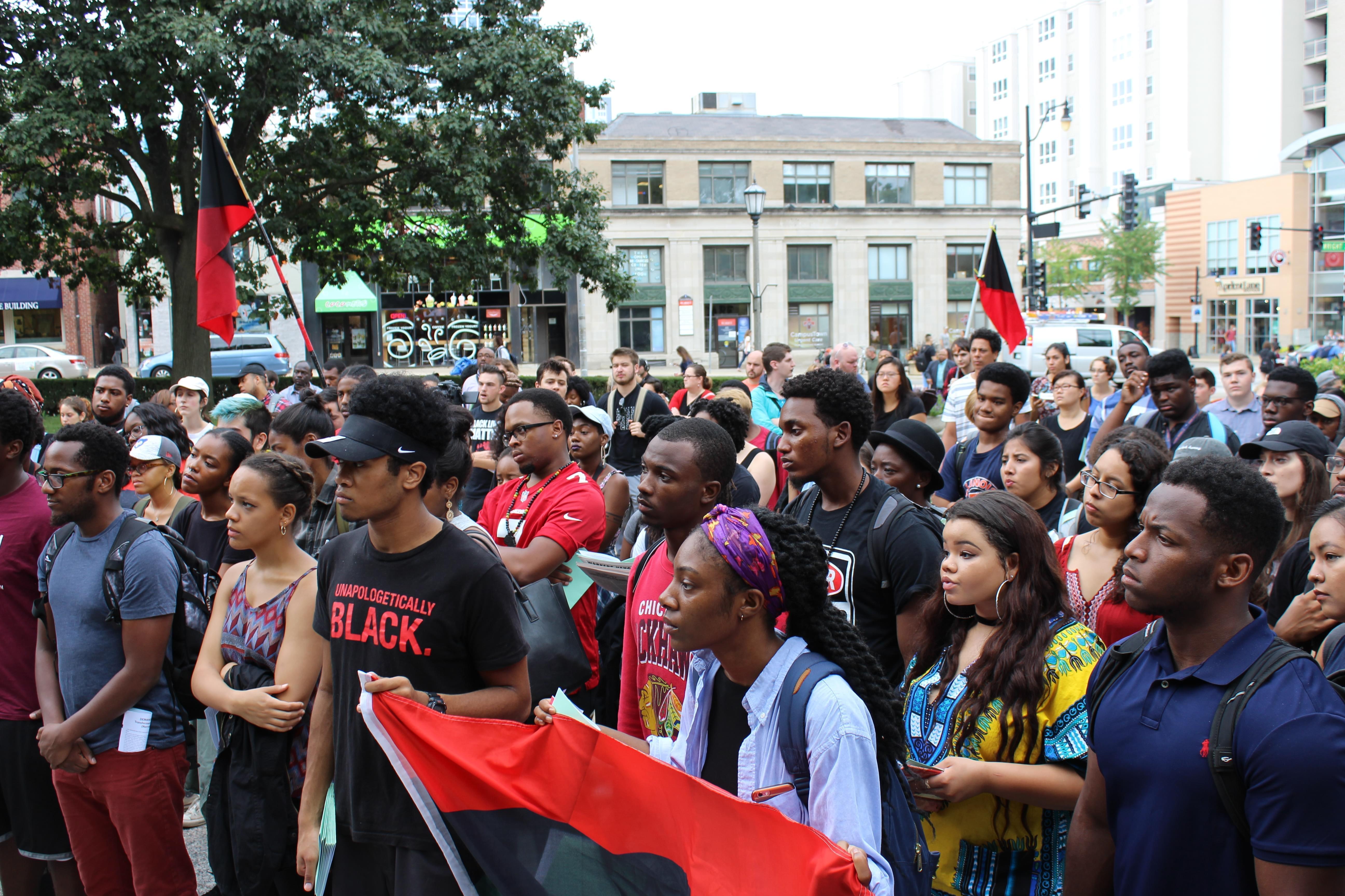 About 150 students listen to a series of speakers during Friday's rally at the U of I alma mater statue.