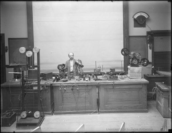 Joseph Tykociner, University of Illinois professor of electrical engineering, stands with all of the equipment used to create sound motions pictures in the world's first successful demonstration of sound on film. This demonstration was in the Ph