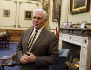 Indiana Gov. Mike Pence speaks after a meeting with Indianapolis Archbishop Joseph Tobin at the Statehouse Wednesday, Dec. 2, 2015, in Indianapolis, a day after the archdiocese said it has the means to resettle a Syrian refugee family bound for the s