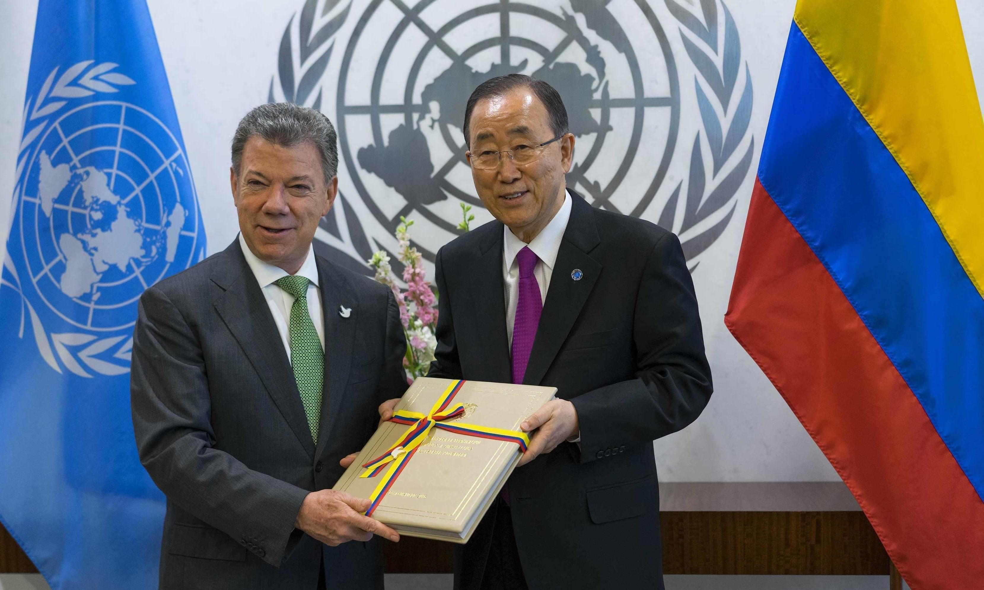 President Juan Manuel Santos of Colombia presents a copy of a peace agreement that was forged in his country to United Nations Secretary-General Ban Ki-moon.