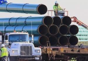 workers unload pipes for the proposed Dakota Access oil pipeline that would stretch from the Bakken oil fields in North Dakota to Illinois.