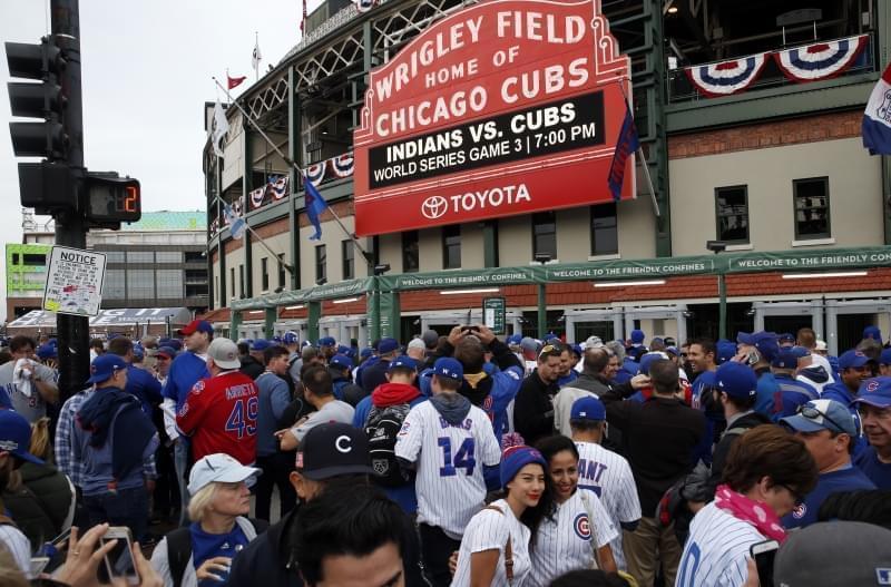 Fans wait in front of the Wrigley Field marquee as they arrive before Game 3 of the  World Series between the Chicago Cubs and the Cleveland Indians, Friday, Oct. 28, 2016, in Chicago.