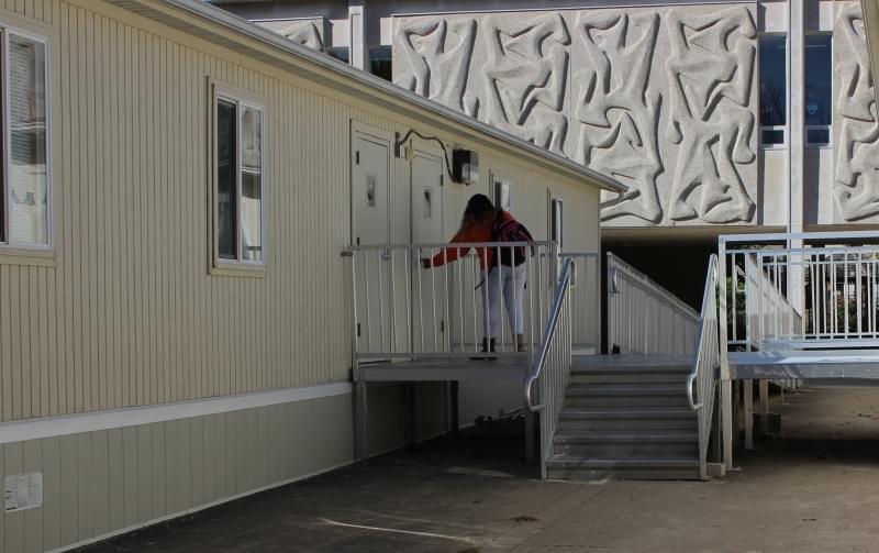 A student enters a portable classroom outside of Centennial High School.