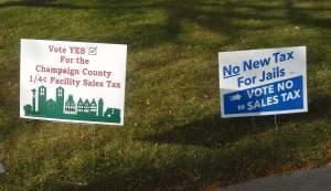 Two yard signs, one for and one against the Champaign County Facilities Sales Tax referendum.