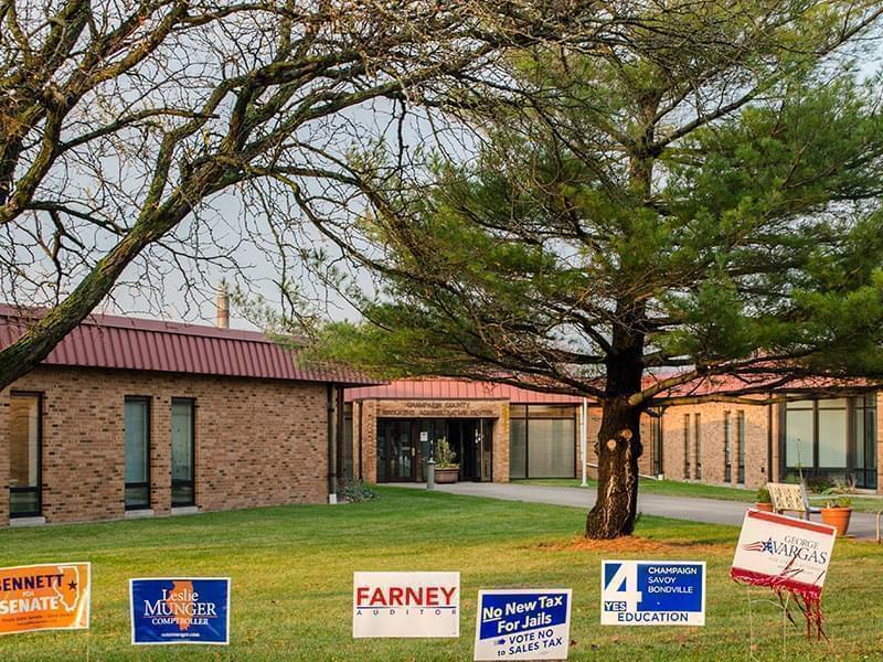 Campaign signs are lined up outside the entrance of the Champaign County Clerk's Office in the Brookens Center in Urbana on Election Day