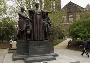 In this April 28, 2014 photo, students walk past the Alma Mater statue, a landmark on the University of Illinois campus in Urbana.