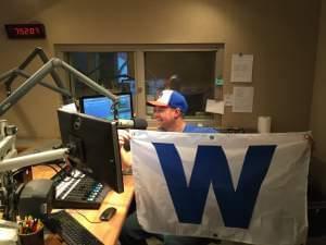 A man holding a Cubs "W" flag.
