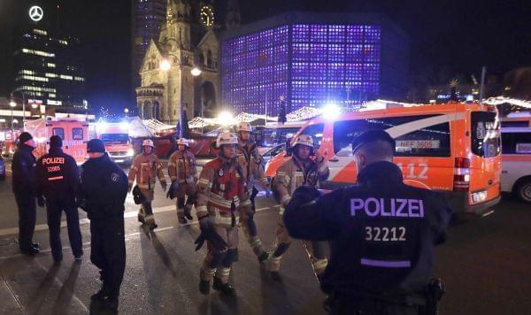Firefighters walk past ambulances after a truck ran into a crowded Christmas market and killed several people in Berlin, Germany, Monday, Dec. 19, 2016.
