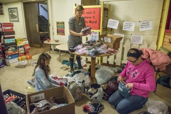 From left: Elana Whitsitt, Oksana Whitsitt and Brooke Riddell organize gifts as volunteers gathered to wrap gifts for the women and children of Courage Connection at Trinity Lutheran Church, Urbana, Il on December 15, 2016. 