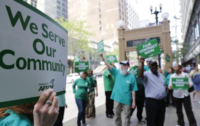 In this June 9, 2015 photo, members of the American Federation of State, County and Municipal Employees protest outside the in Chicago. 