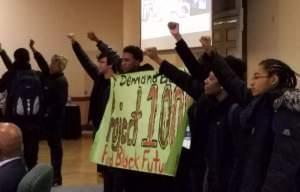 Members of the Black United Front unfurl a banner at a University of Illinois trustees meeting on March 15, 2017.