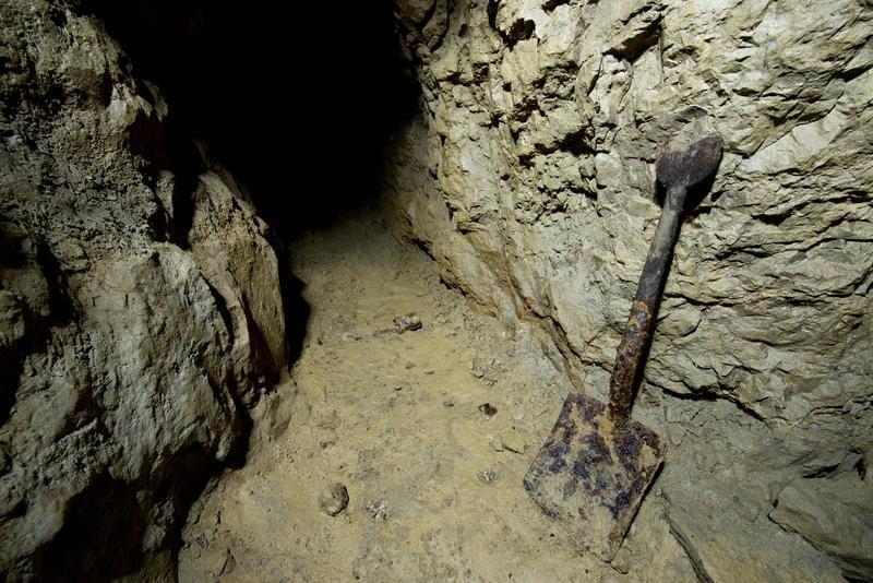 A shovel at the entrance to a cave.