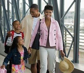 mom, Dad, and two children walking through the airport