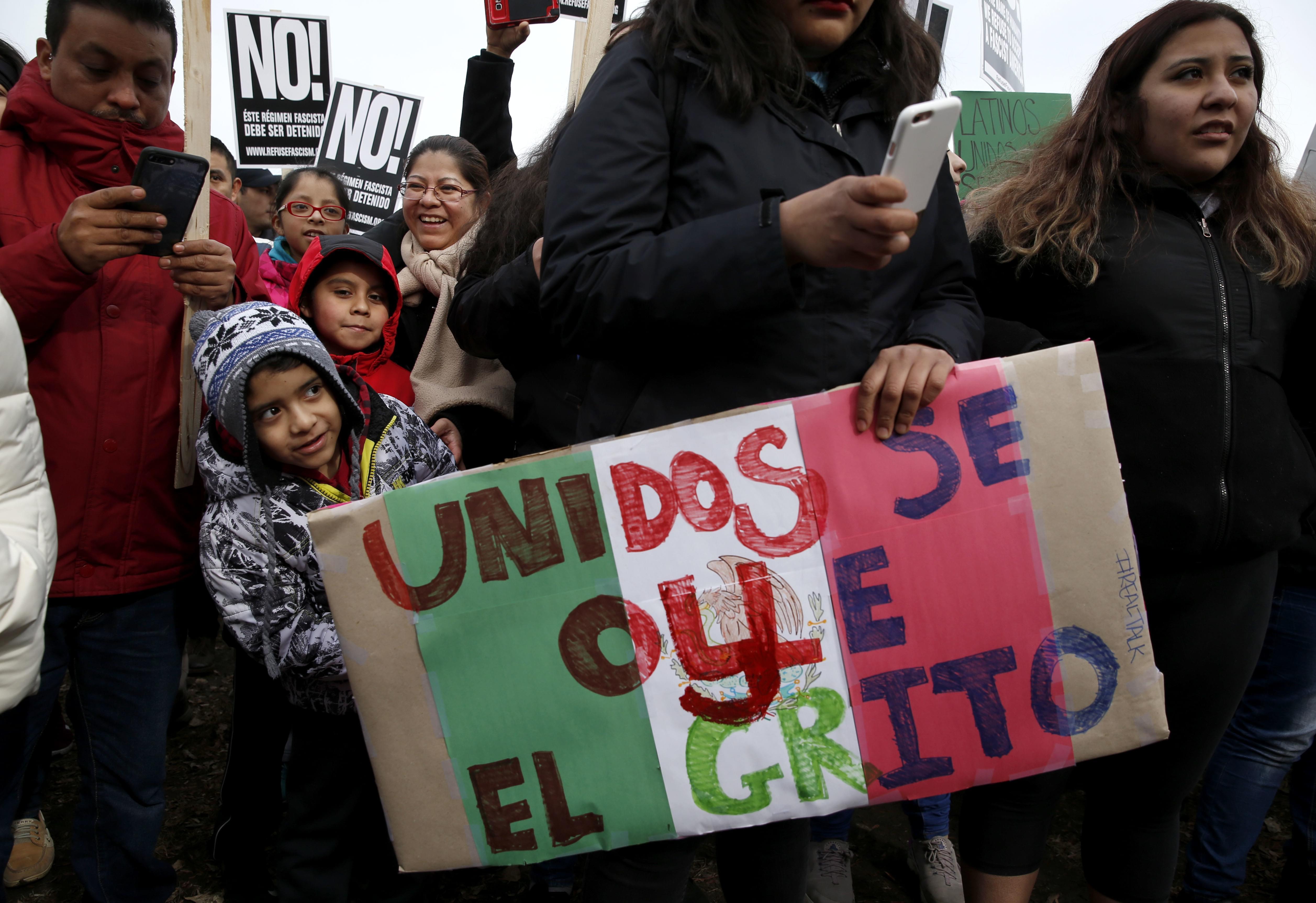 Protestors participate in a march holding signs aimed at President Donald Trump's efforts to crack down on immigration laws in Chicago.