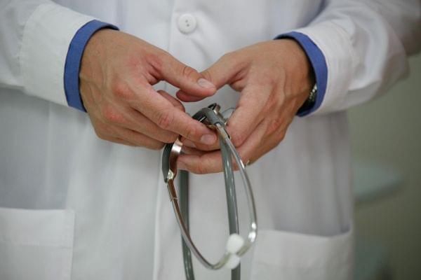 A doctor holds a stethoscope. 