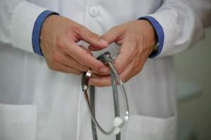 A doctor holds a stethoscope. 
