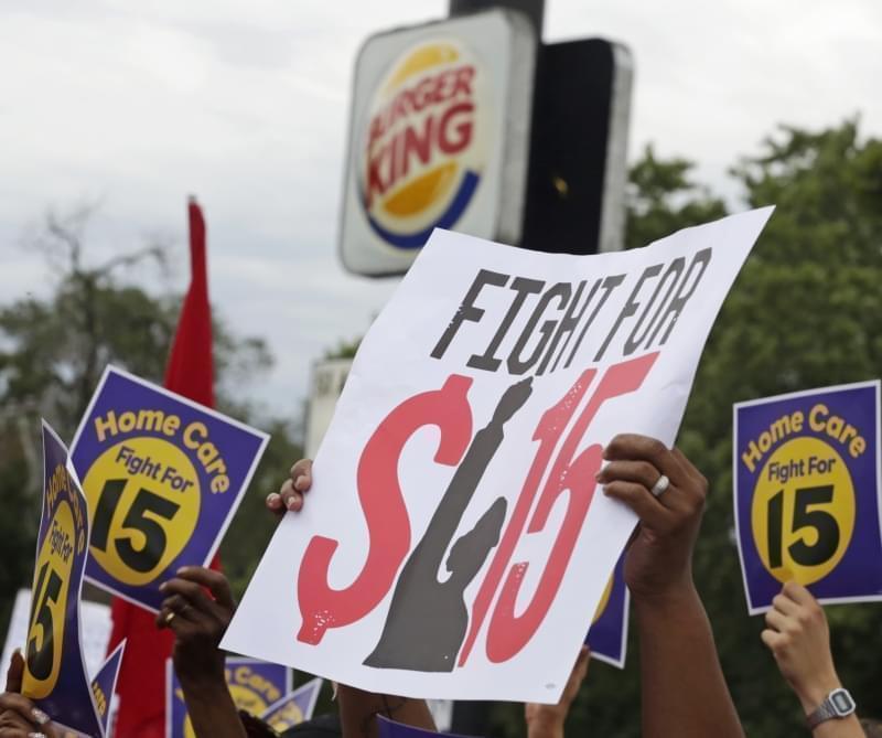 Labor organizers hold banners during a protest to raise the minimum wage for employees to $15 an hour in Illinois. 