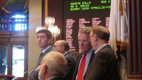 House Speaker Michael Madigan, second from right, confers with aides while watching the end of the debate on legislation to raise Illinois' income tax rate.