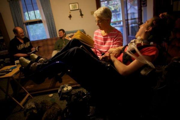 Olivia Welter's mom, Tamara, reads to her in the family's living room in 2010, with her father John and brother Brian in Lincoln, Ill. Now, nurses care for Welter 16 hours a day. John and Tamara take over the other eight hours. If they lose