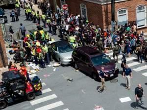 People receive first aid after a car ran into a crowd of protesters in Charlottesville, Va., on Saturday. The car struck the silver vehicle pictured, sending marchers into the air.