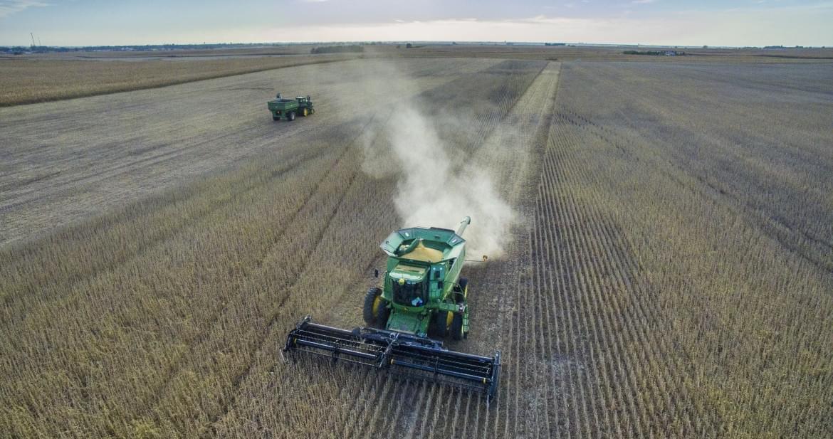 A tractor in a corn field during harvest time.