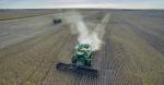 A tractor in a corn field during harvest time.