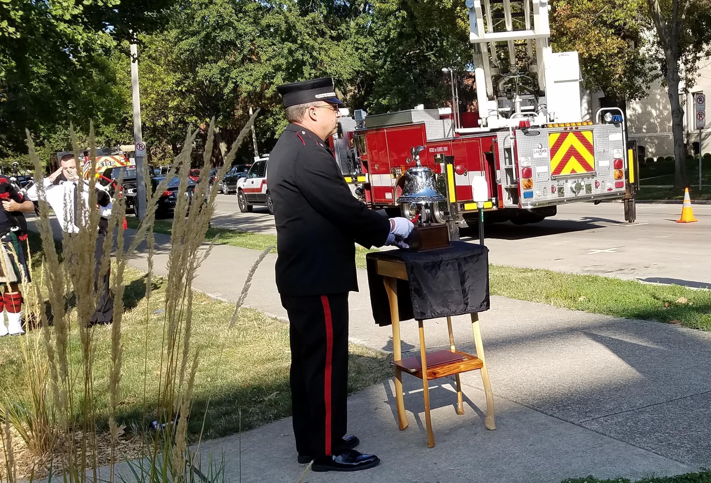 Member of Champaign Fire Dept. honor guard rings a bell in memory of those killed in the Sept. 11 2001 attacks.