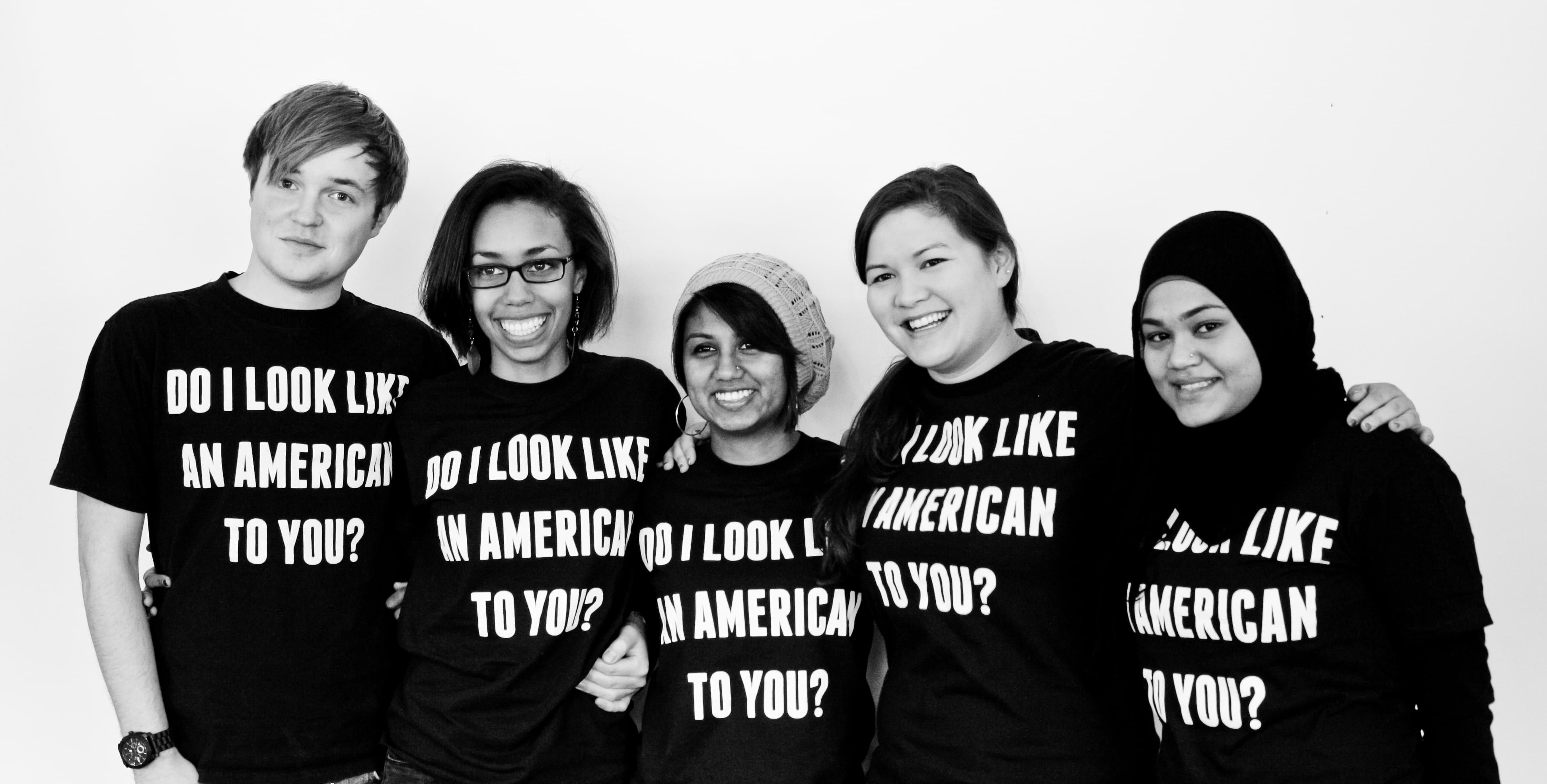 University YMCA students wearing shirts saying 'Do I look American to you?'